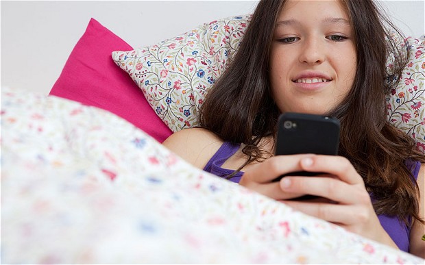 children using phones in bed