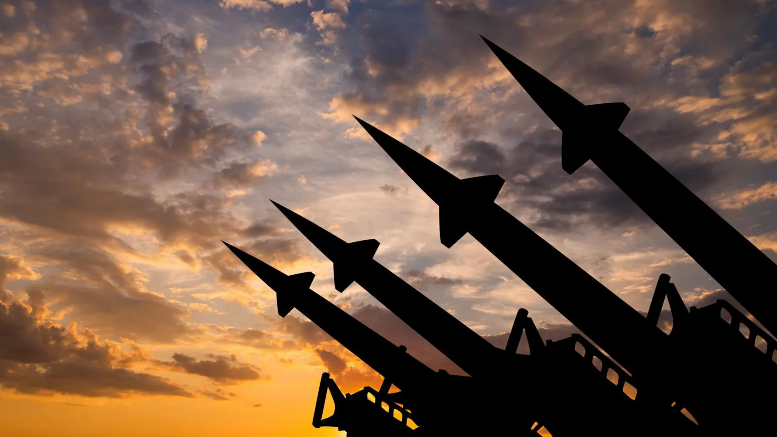 Getty Images Silhouettes of four missiles pointing upwards against a cloudy skyline