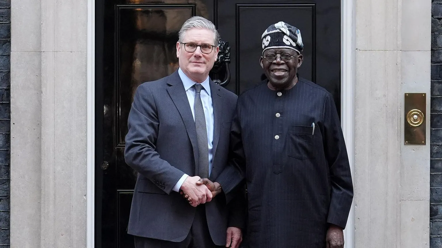 PA Media Prime Minister Sir Keir Starmer shakes hands with Nigerian President Bola Ahmed Tinubu outside the black door on 10 Downing Street.