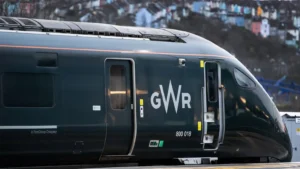 Great Western Railway A green train at a platform with colourful houses slightly out of focus in the background