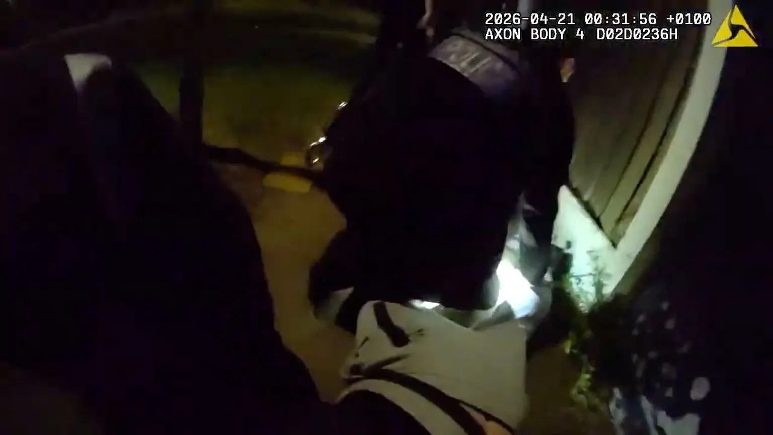 Police officer on the ground arresting a suspect.
