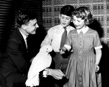 Black and white photograph of Prince Charles and his sister, Princess Anne, with David Attenborough and Cocky the cockatoo