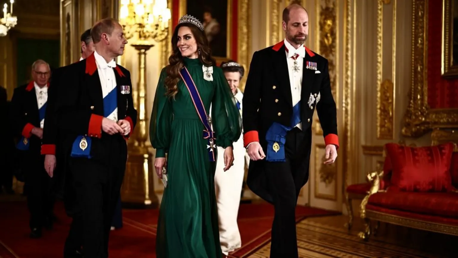 PA Media The Duke of Edinburgh in a black suit walks alongside the Princess of Wales who is wearing a green, long-sleeve floor-length gown and tiara with the Prince of Wales next to her in a black suit
