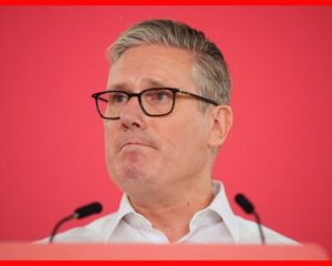 Head and shoulders shot of Starmer against red background