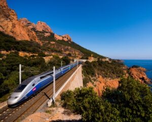 A French high-speed train TGV running over a viaduct alongside the Mediterranean coast