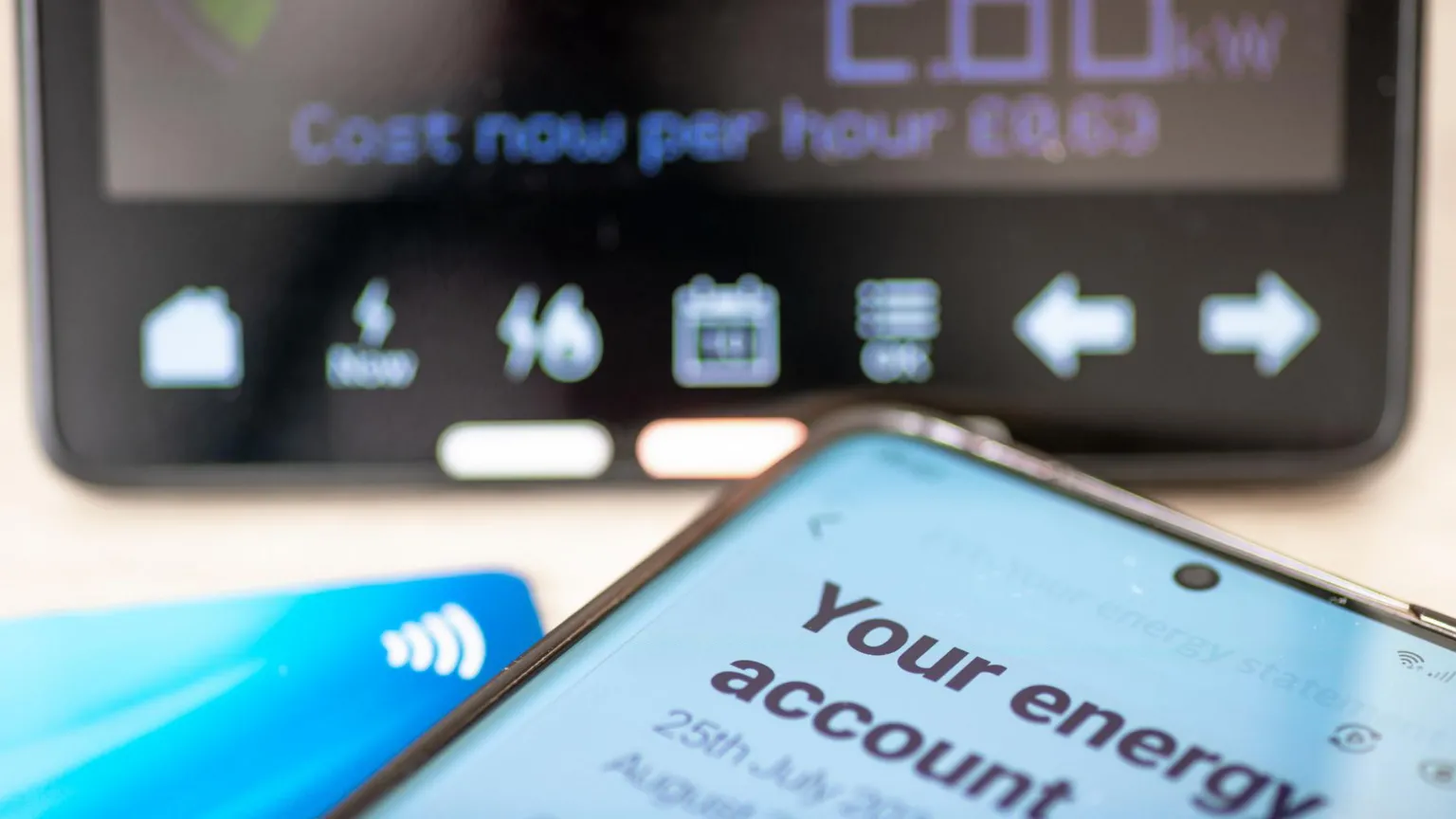 Getty Images Energy account on phone next to bank card and in front of smart meter reading.