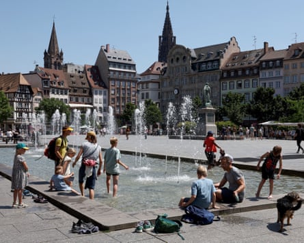 Local residents and tourists cool off at the fountain of the Place Kléber in Strasbourg