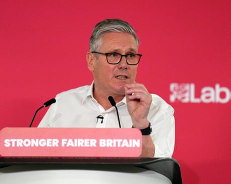 Starmer in white open collar shirt speaking at lectern with 'Stronger Fairer Britain' written on it
