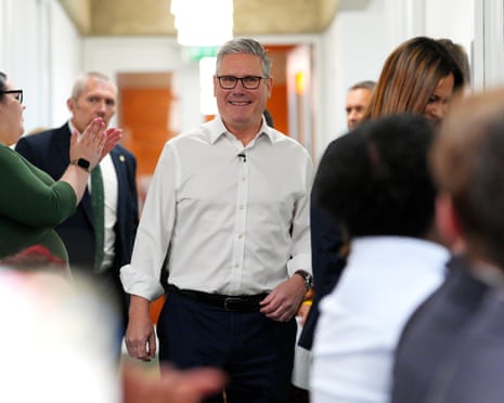Starmer walks through a crowd as someone applauds
