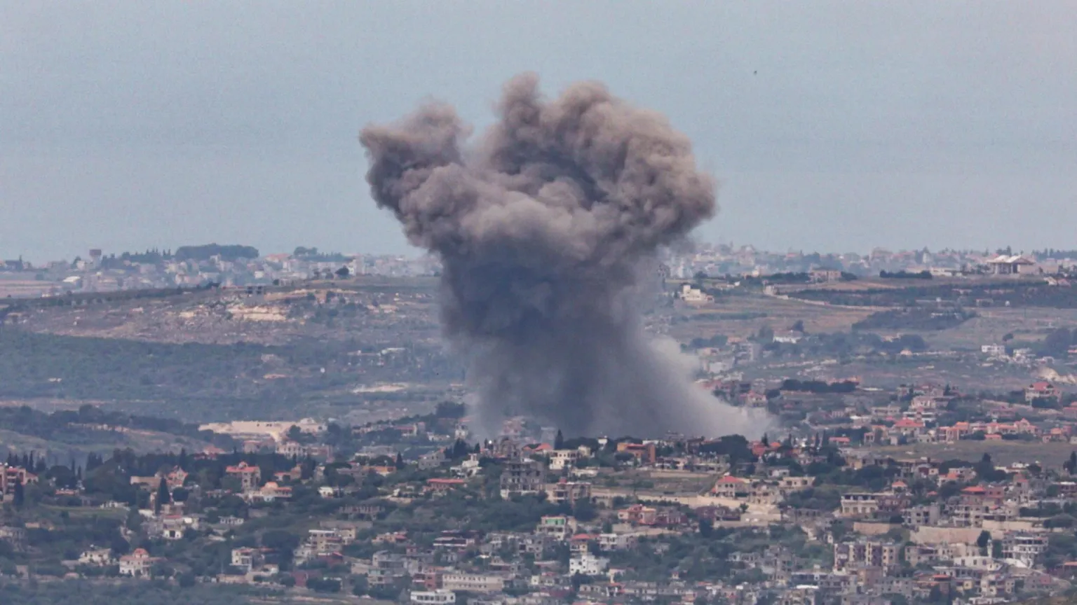 Smoke rises after an Israeli strike on a village in southern Lebanon, as seen from northern Israel (12 May 2026)