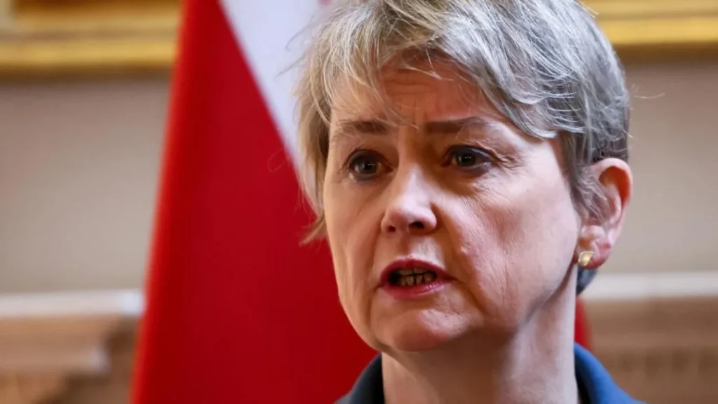 PA Media Foreign Secretary Yvette Cooper is speaking and stood in front of a flag. She is wearing a blue jacket.