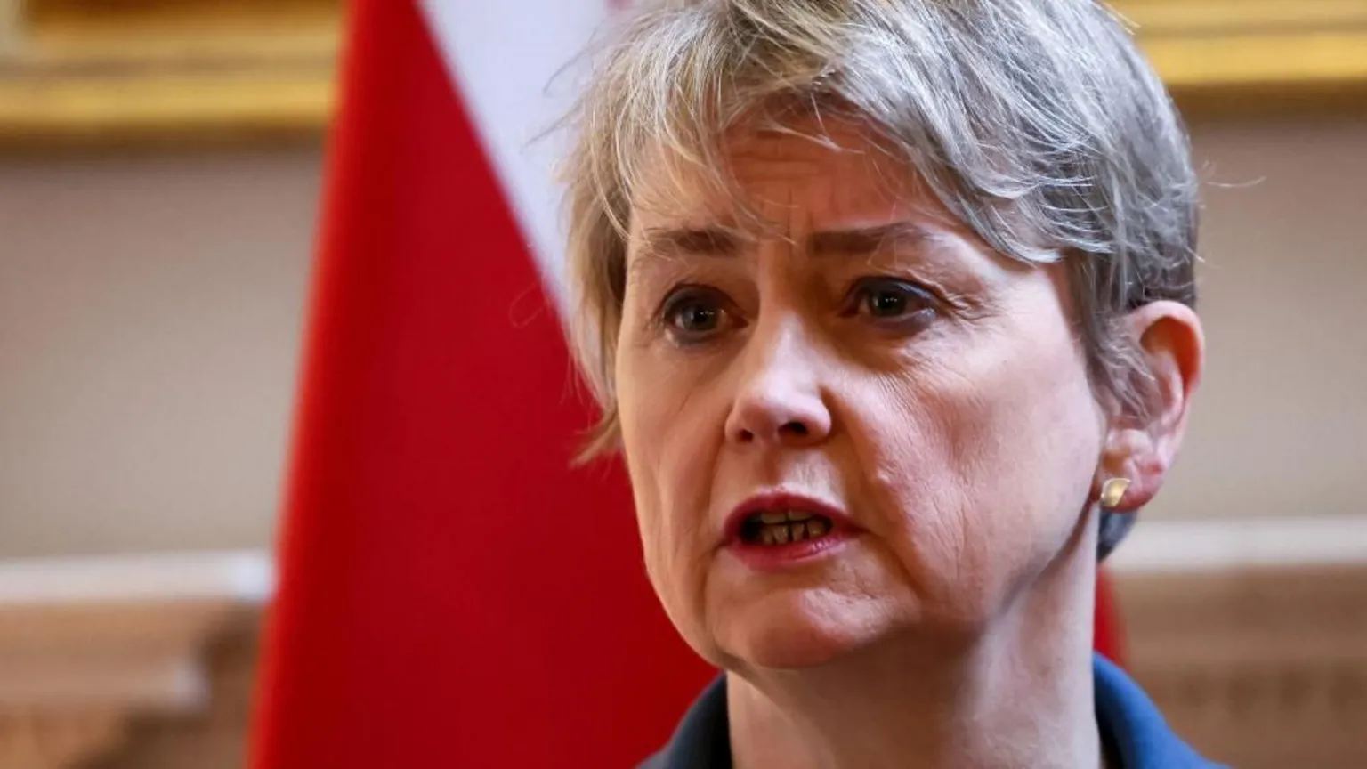PA Media Foreign Secretary Yvette Cooper is speaking and stood in front of a flag. She is wearing a blue jacket.