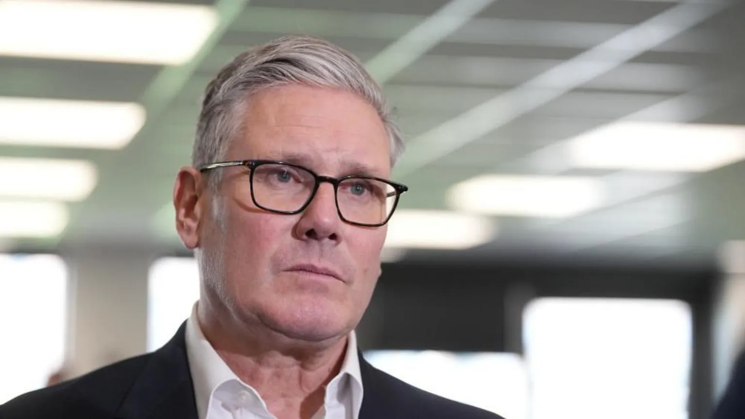 A headshot of Keir Starmer who looks slightly beyond the camera and has a neutral expression on his face.