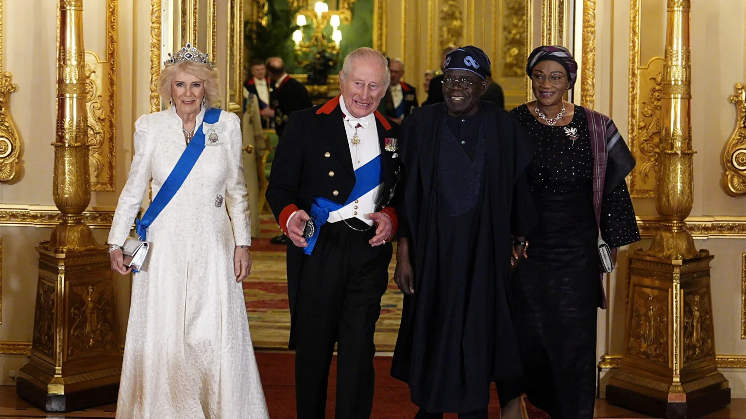 PA Media Britain's Queen Camilla in a floorlength cream dress, King Charles III in a black suit jacket and trousers and white waistcoat, Nigeria's President Bola Tinubu in a navy blue outfit and Nigeria's First Lady Oluremi Tinubuin an all-black ensemble