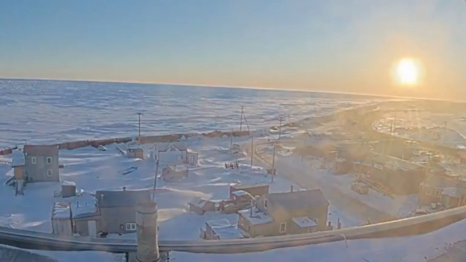 Utqiagvik, Alaska is seen with the sun in the sky.