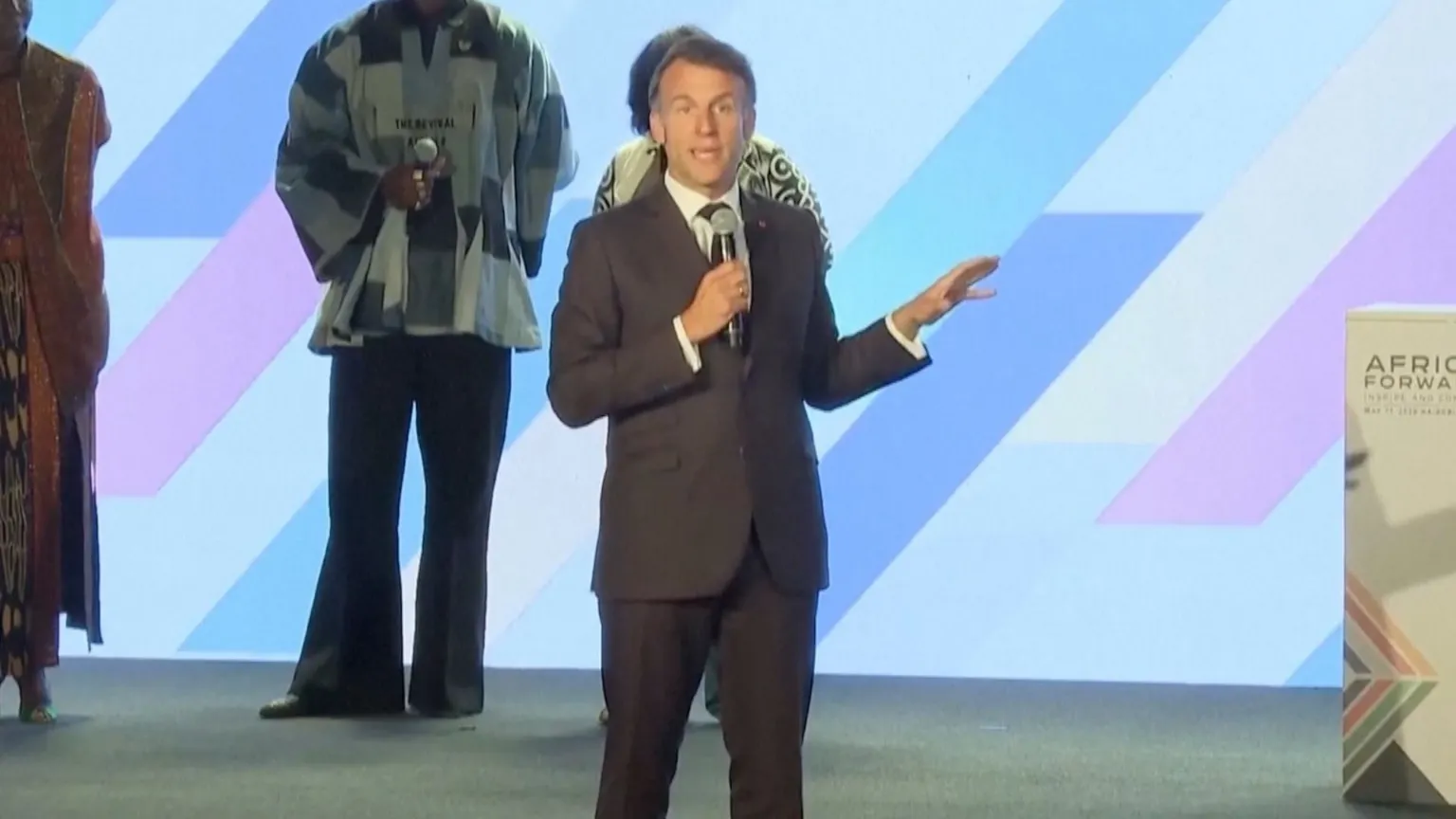 Macron on stage with a mic at the Africa Forward summit