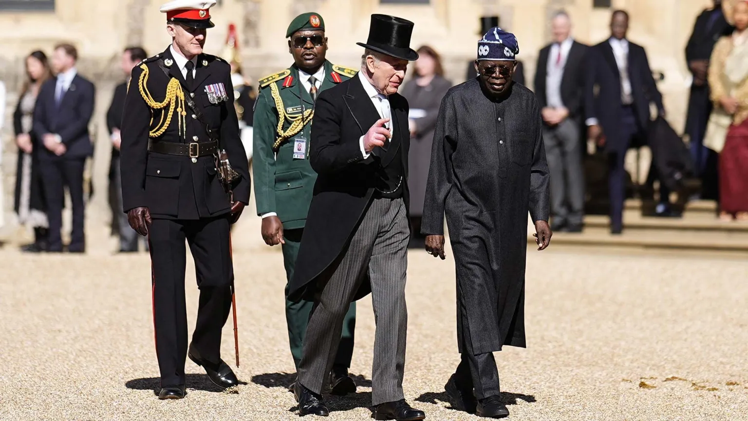 Reuters King Charles III with the President of Nigeria Bola Ahmed Tinubu on the Royal Dais during a welcome ceremony at Datchet Road in Windsor. Both men are dressed in black, with King Charles in a three-piece suit
