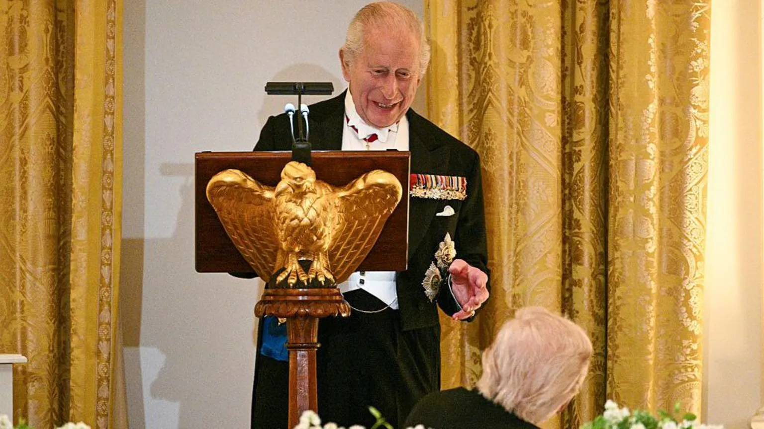 The King grins at Trump from the lectern as the president looks in his direction