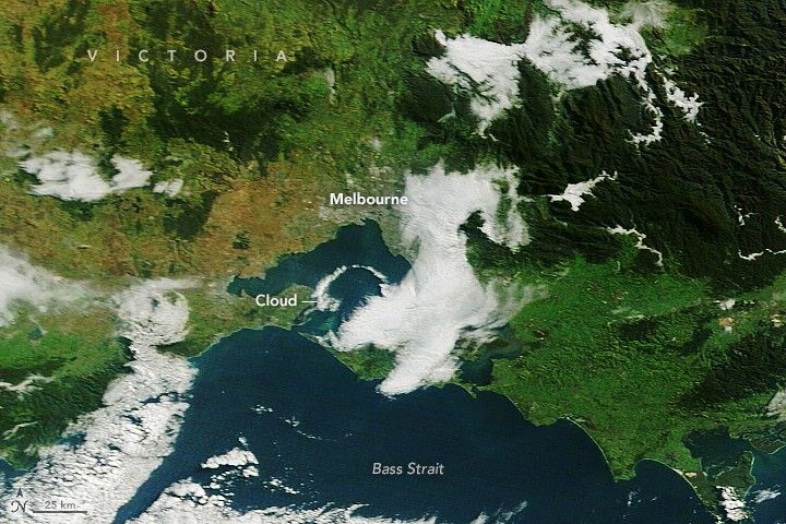 A narrow arch-shaped cloud is visible over the blue waters of Port Phillip Bay.
