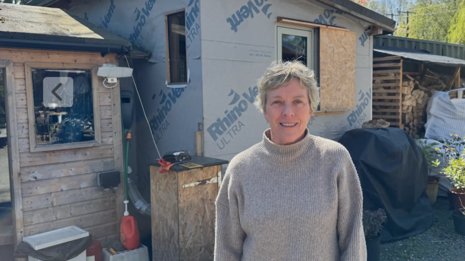BBC Jane Coyle, a woman in her 60s, is standing in front of a shed made of chipboard