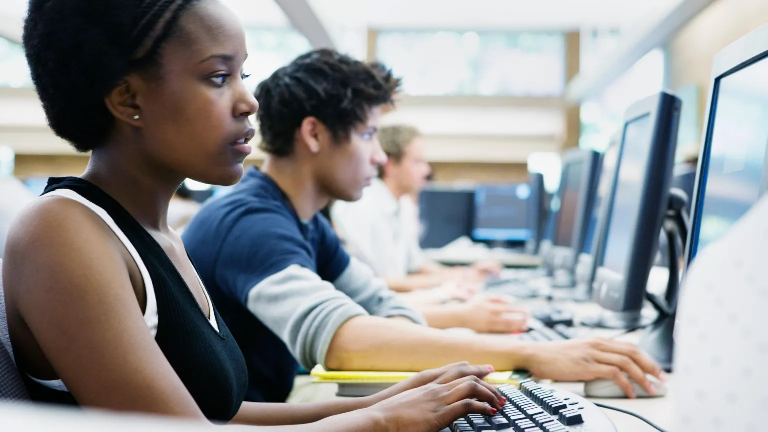 A stock image of US university students in exams. There are a row of students in front of computers