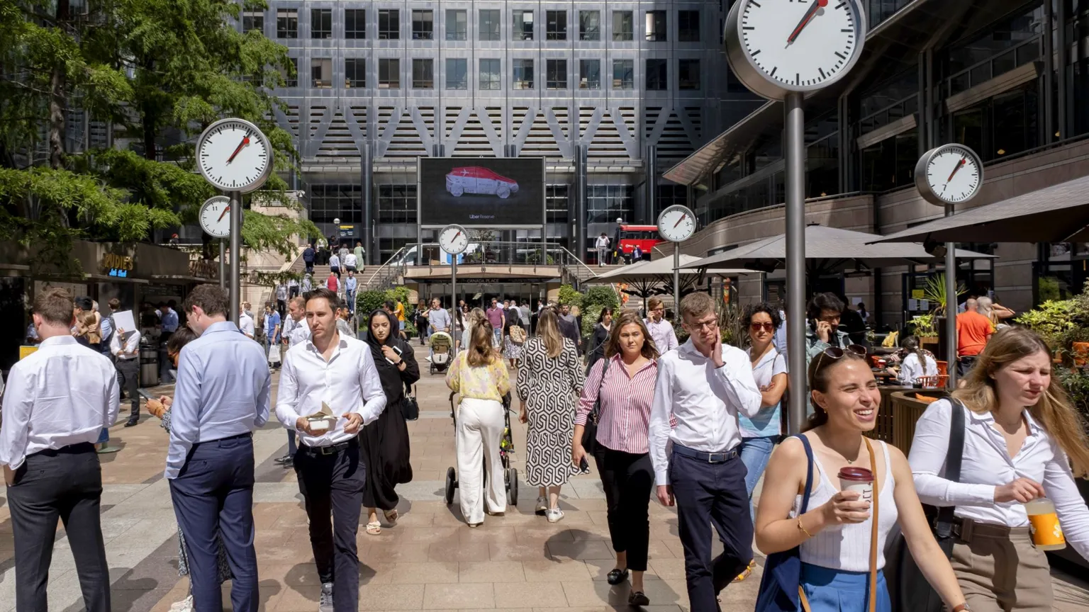 People walk around Canary Wharf in London