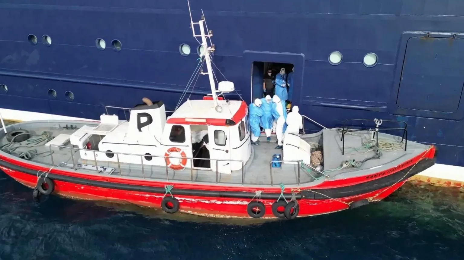 Passenger being evacuated from cruise ship onto a smaller boat.