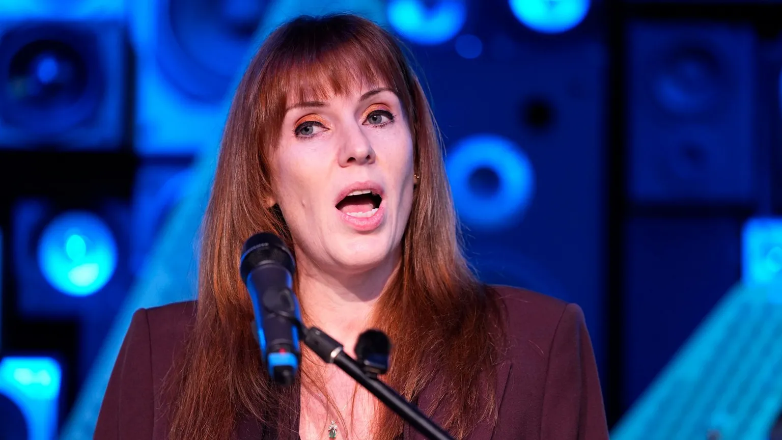 PA Media Angela Rayner speaks into a microphone against the backdrop of speakers at a Liverpool night club
