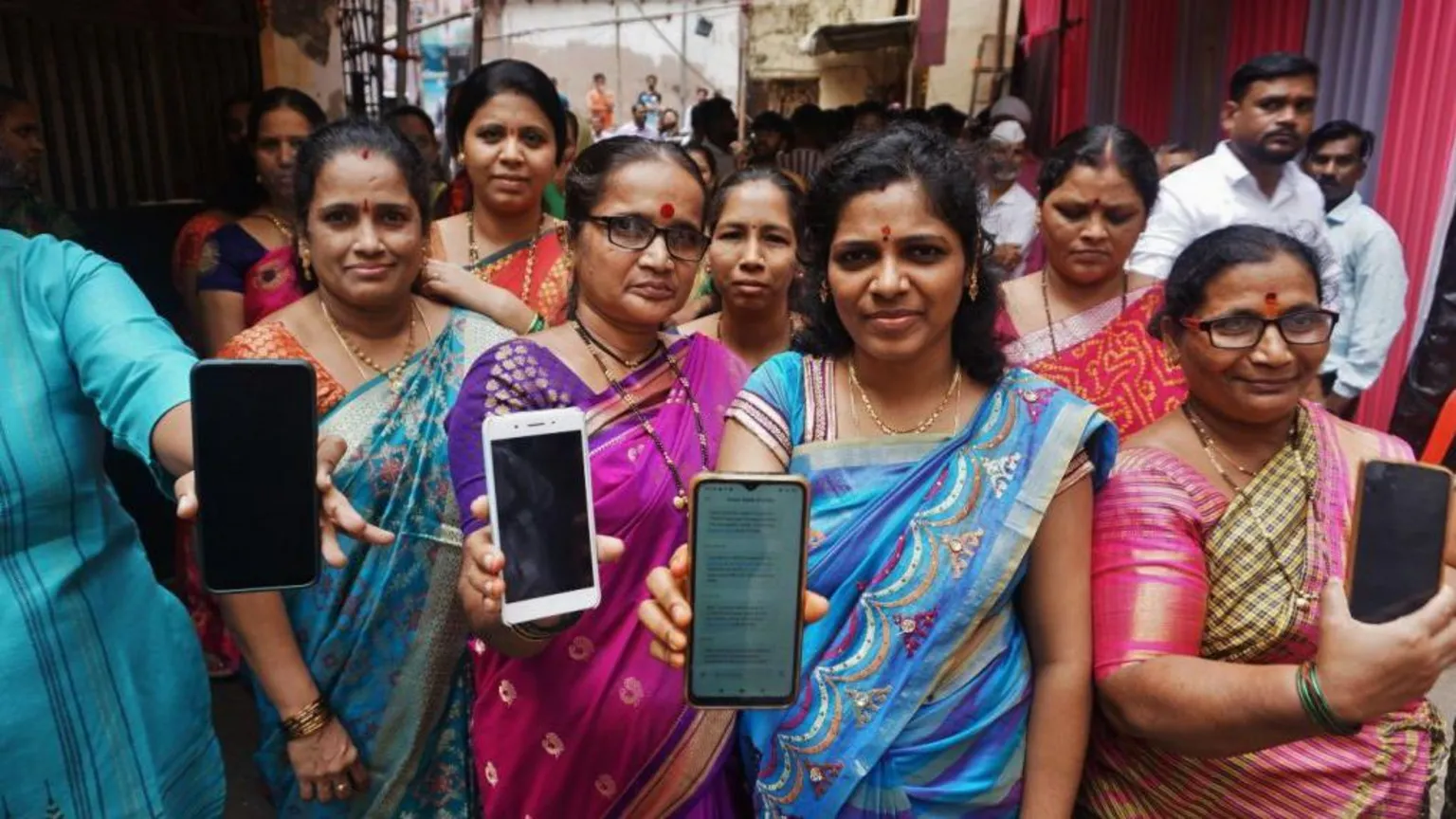 Hindustan Times via Getty Images  Women who were beneficiaries of mukhyamantri ladaki bahin yojana showing their bank passbooks and the message of the scheme money received in thier mobile phones at Kisan Nagar on September 10, 2024 in Thane, India.