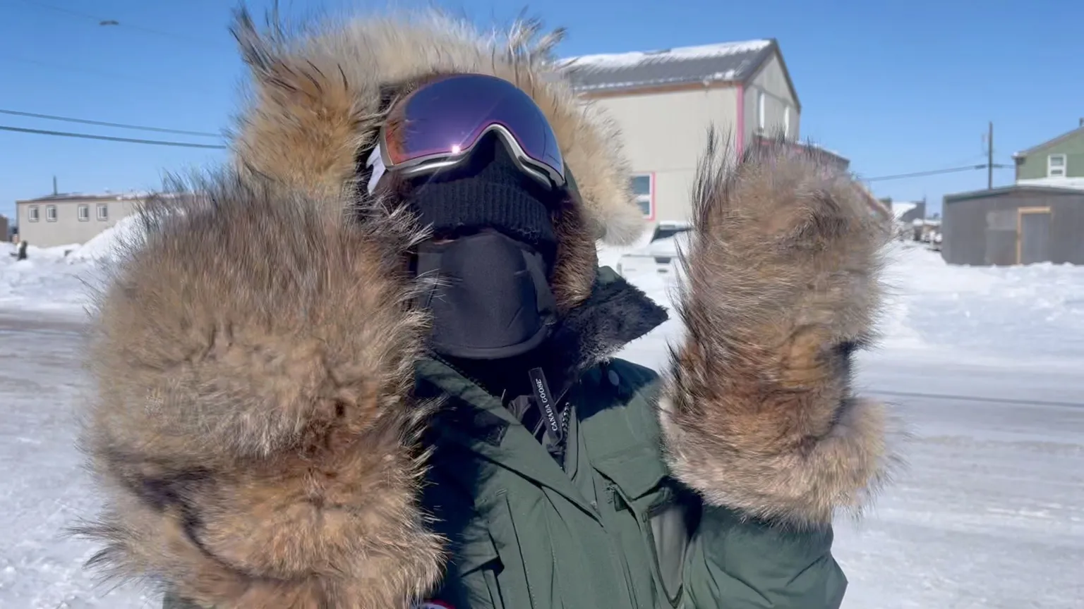Nadine wrapped up in arctic gear. She has a fur coat, beaver fur gloves, and lots of equipment on her face.