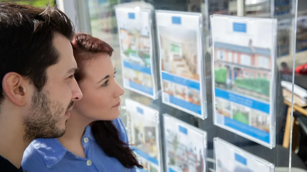 Getty Images A young man and woman stand alongside each other looking at an estate agents' window.