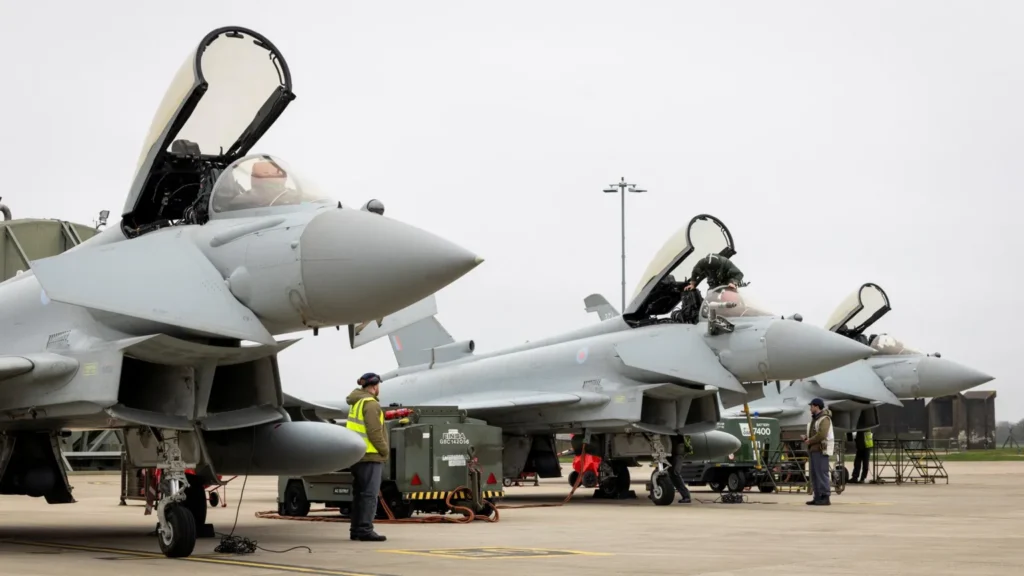 Reuters Three RAF Typhoon aircraft, with their canopies open, prepare to depart RAF Coningsby for Qatar