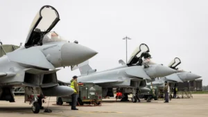 Reuters Three RAF Typhoon aircraft, with their canopies open, prepare to depart RAF Coningsby for Qatar
