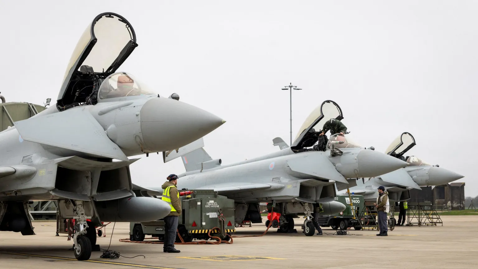Reuters Three RAF Typhoon aircraft, with their canopies open, prepare to depart RAF Coningsby for Qatar
