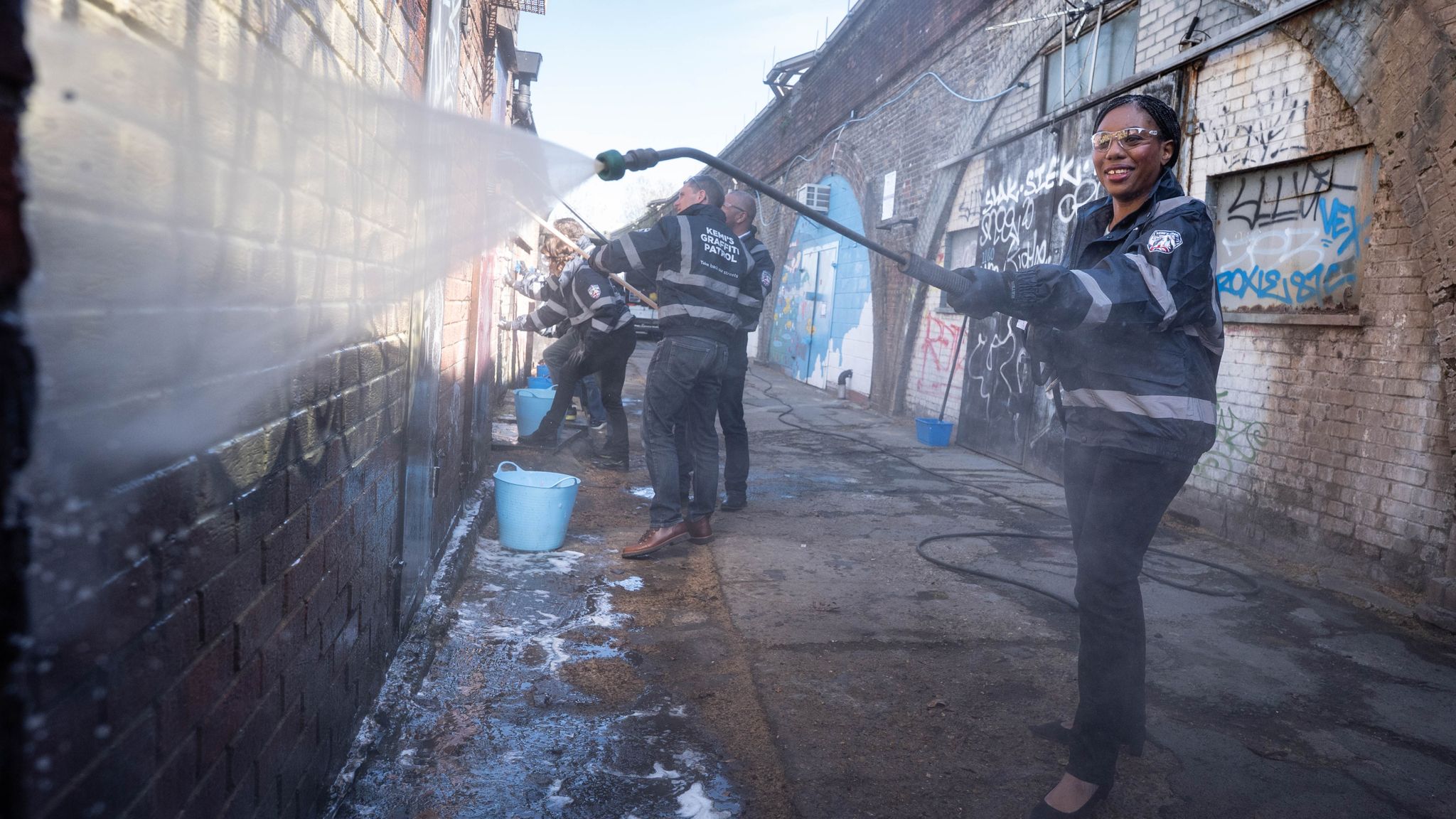 Ms Badenoch cleaning graffiti off a wall in Herne Hill, south London. Pic: PA